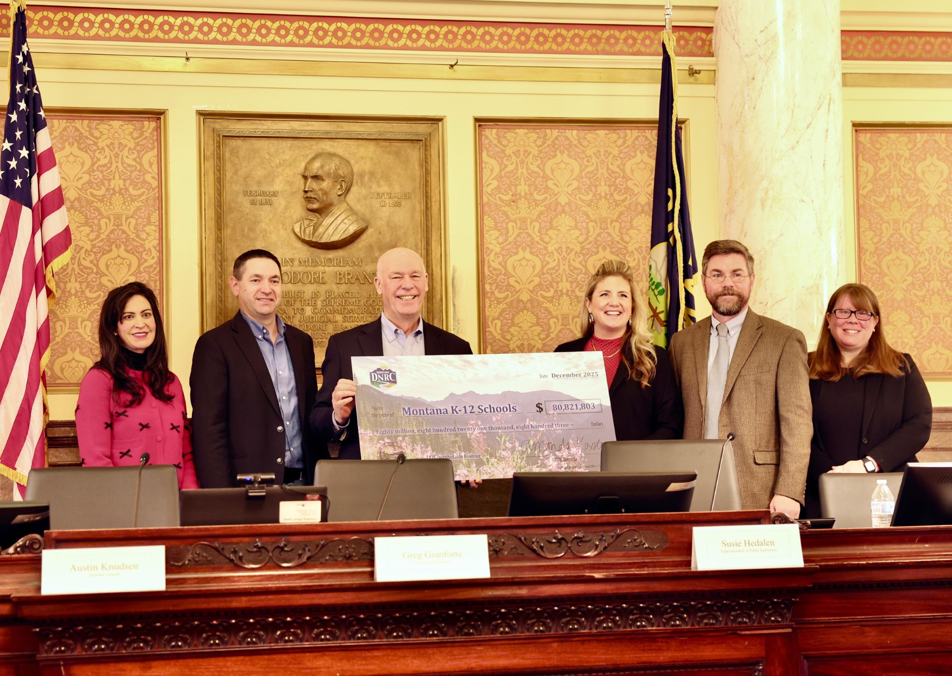 Gov. Gianforte holding a check for $80.8 million for Montana public schools during a meeting of the Land Board