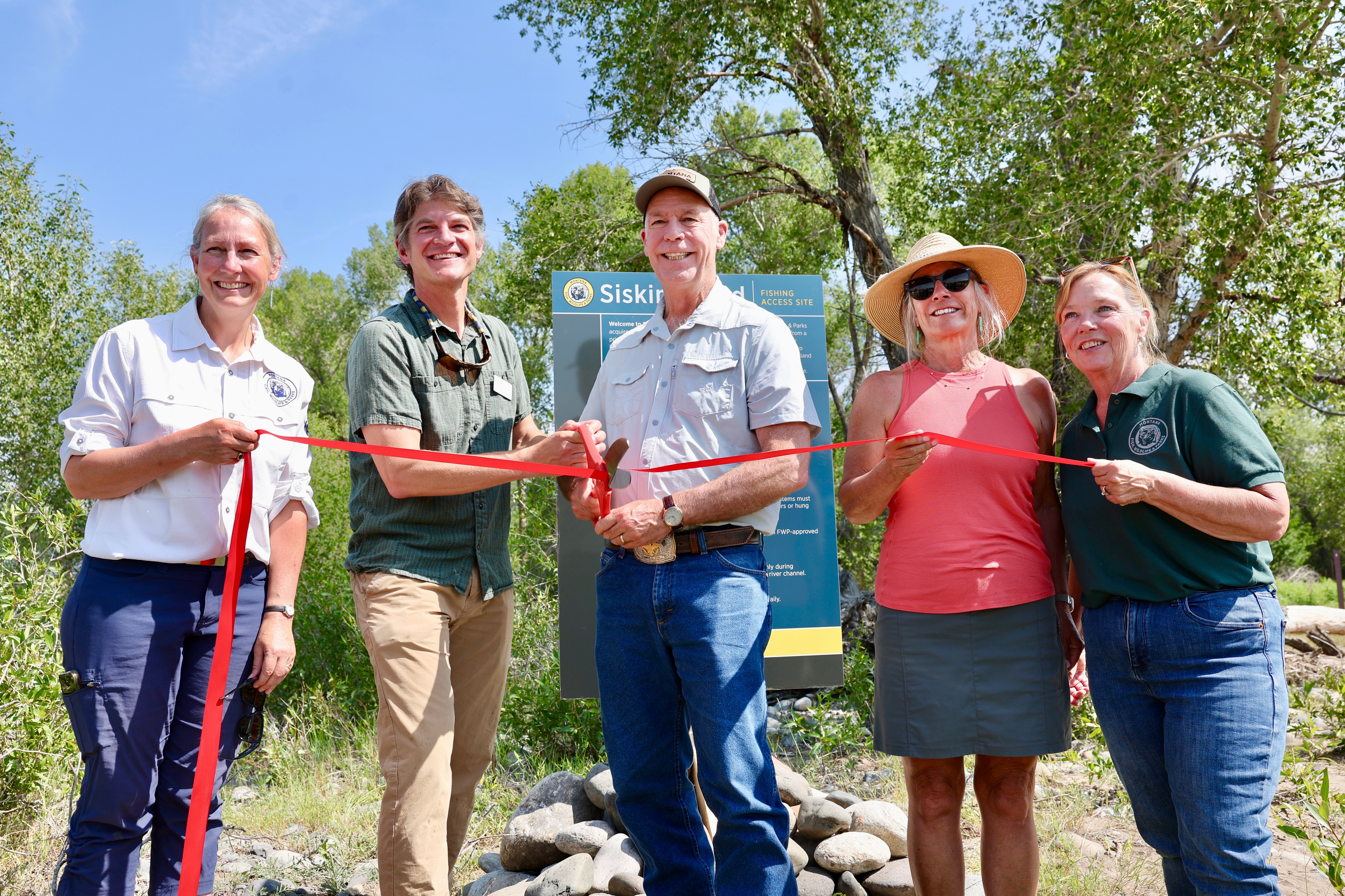 Gov. Gianforte (center) and FWP Director Christy Clark (right) helping cut the ribbon on Siskin Island Fishing Access Site near Livingston