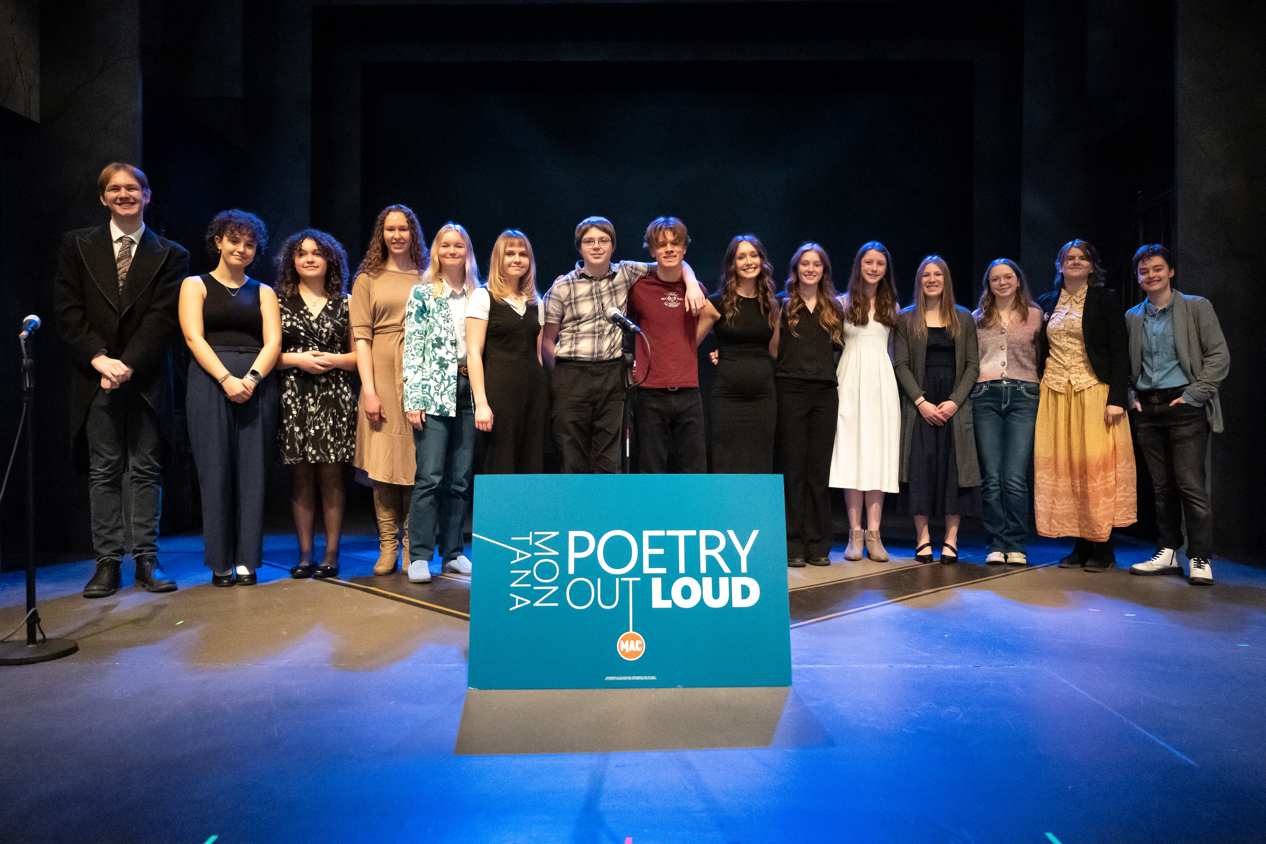 All of the 2026 Montana Poetry Out Loud finalists and alternates on stage with sign and logo