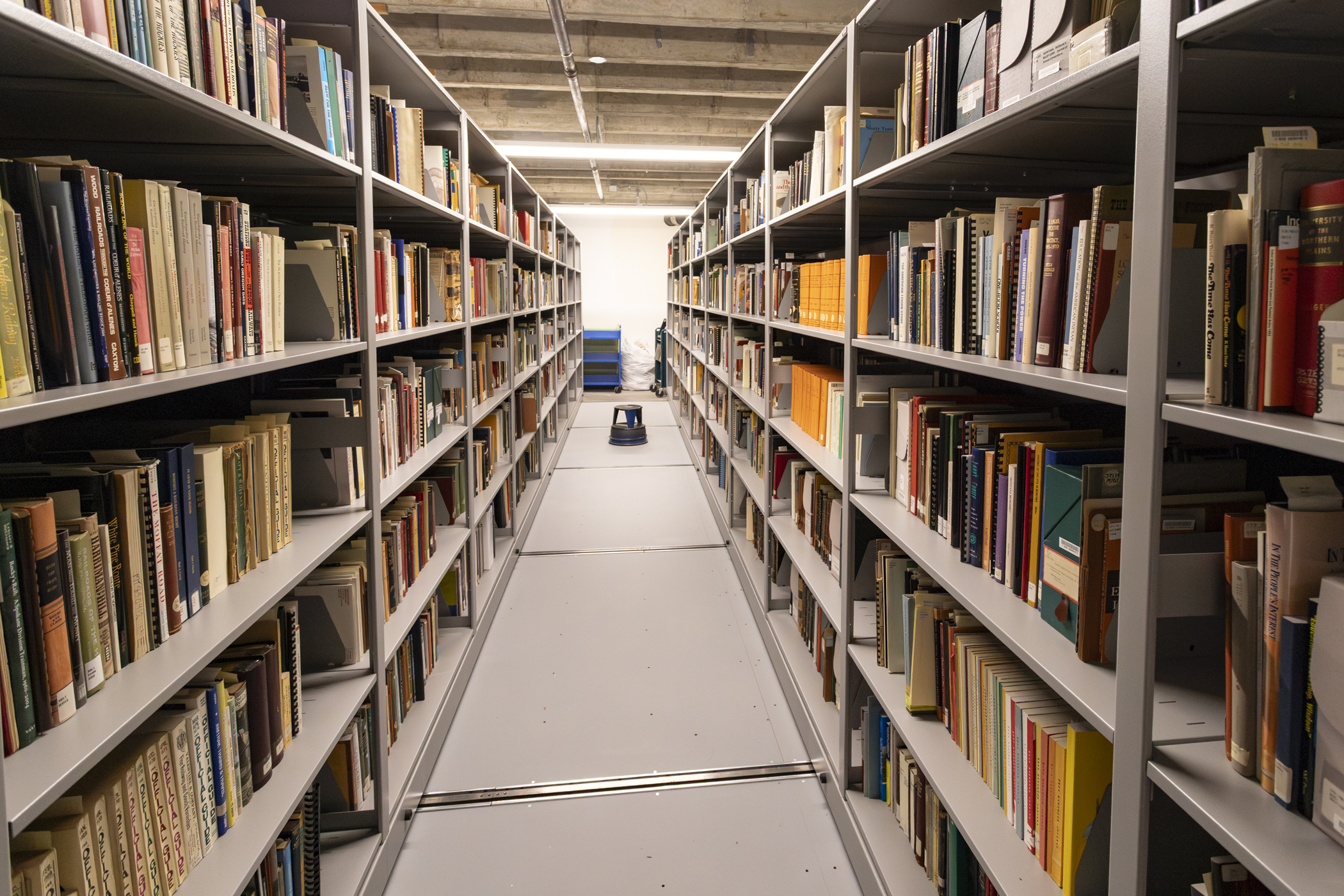 Rows of books line tall bookshelves in the Montana Historical Society Library and Archives.