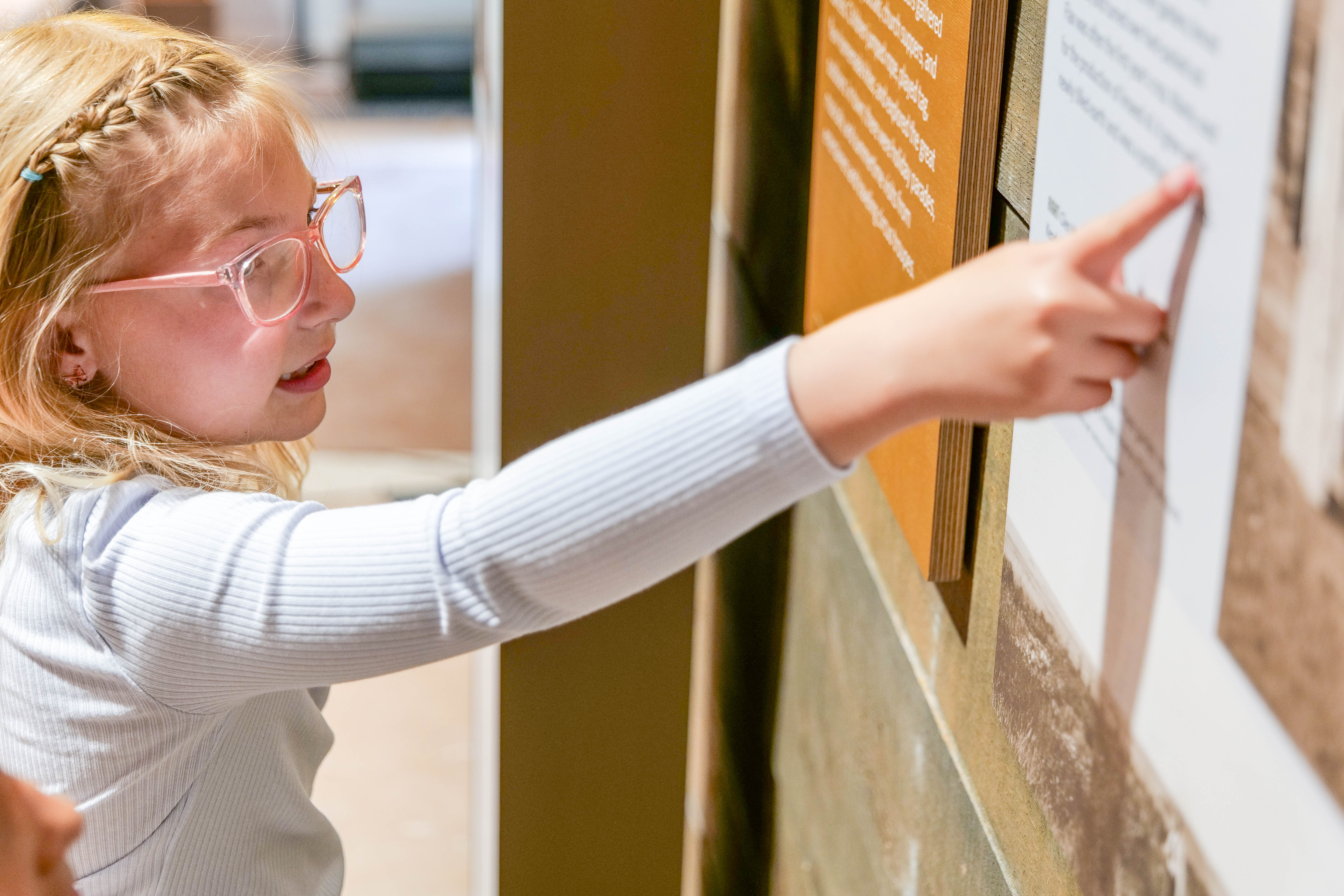 A child reading a museum panel.